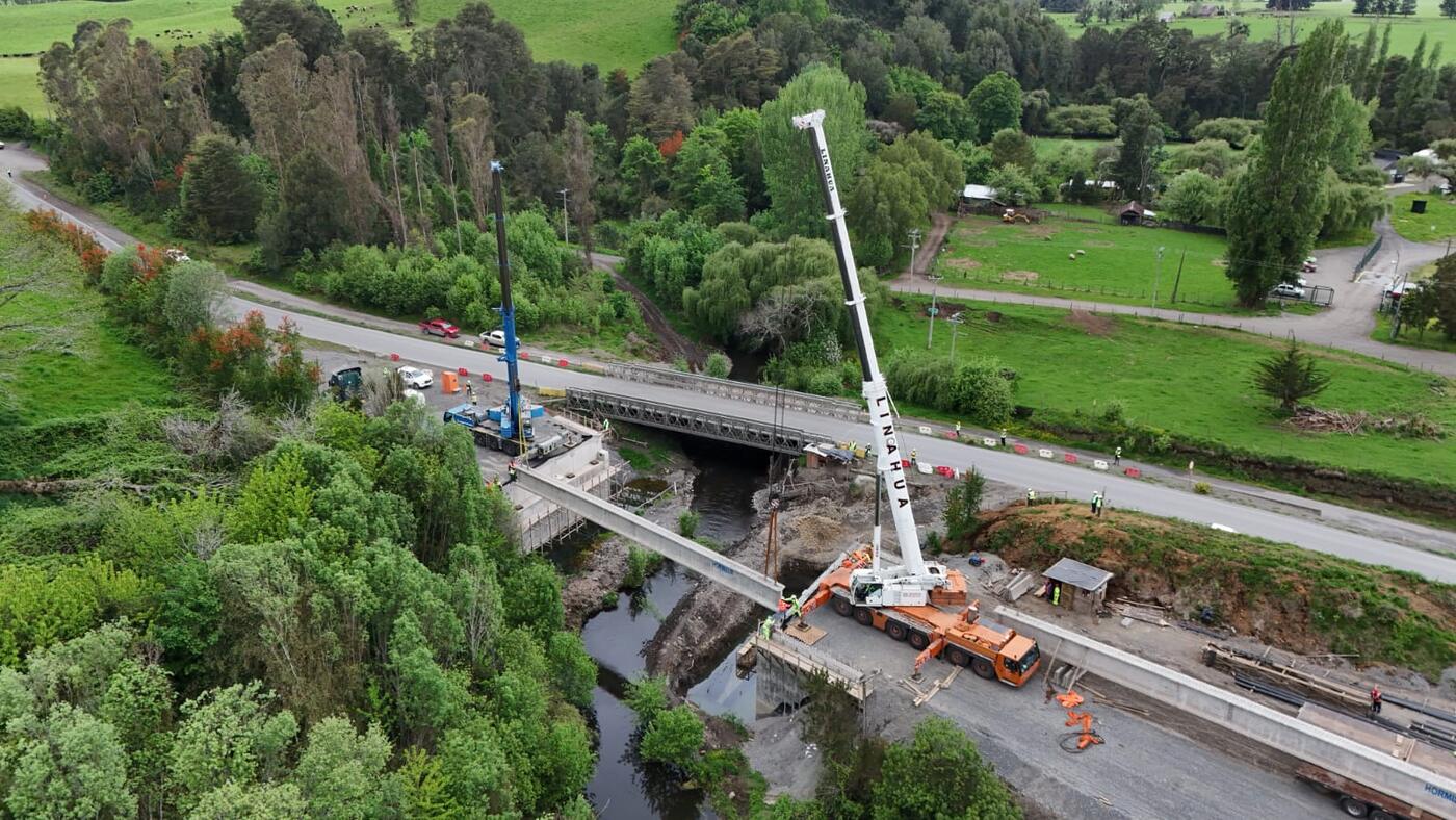 Grúas montando vigas junto a un puente mecano